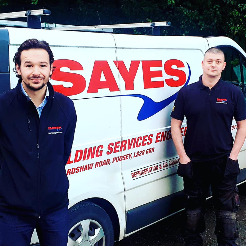 Two Sayes employees standing next to a Sayes branded van