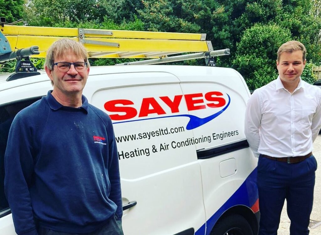 Two members of the Sayes team stood next to a Sayes branded van