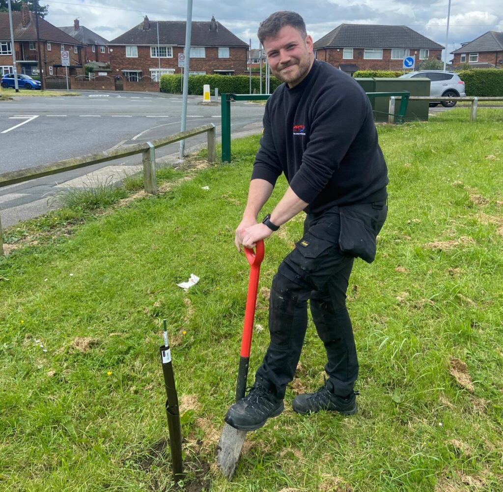 Member of the Sayes team digging and carrying out community work